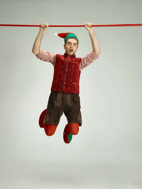 friendly man dressed like a funny gnome posing on gray background - Foto, Imagem