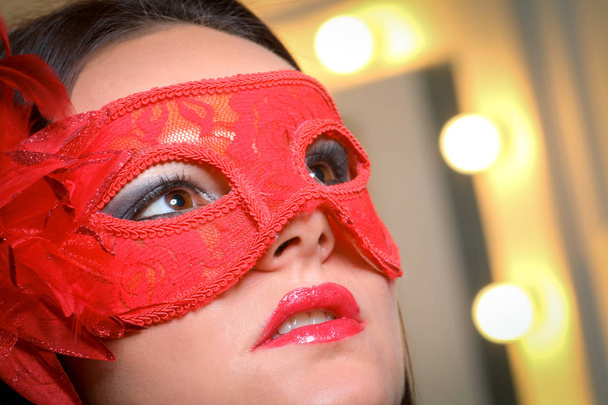 Closeup portrait of sexy woman in red, gold party mask for desire concept at New Year and Christmas party - Photo, Image