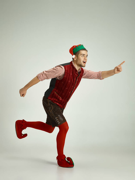 friendly man dressed like a funny gnome posing on gray background - Foto, Imagem