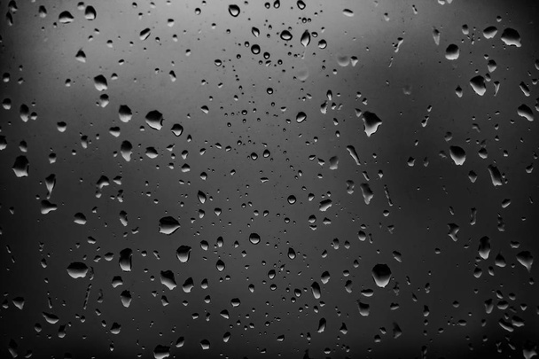 暗いガラスの背景に雨滴 - 写真・画像