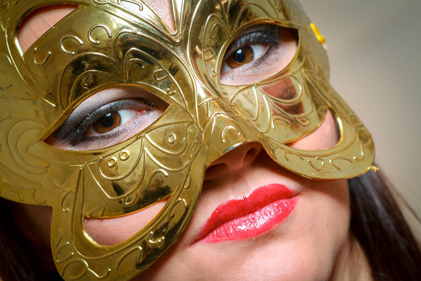 Closeup portret van sexy vrouw in rood, goud partij masker voor wens concept op Nieuwjaar en kerst party - Foto, afbeelding