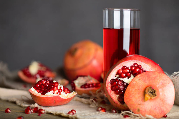 Glass of pomegranate juice on a wooden surface. Closeup  - Photo, Image