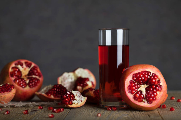 Glass of pomegranate juice on a wooden surface. Closeup  - Photo, Image