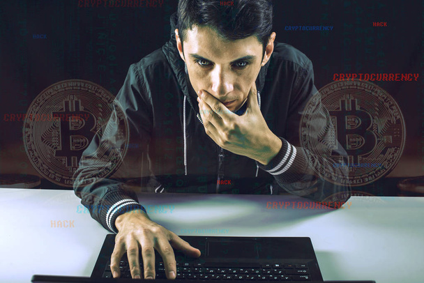 A hacker with a face is trying to steal cryptocurrency using a computer. Fraud and scam at Cryptojacking - Photo, Image