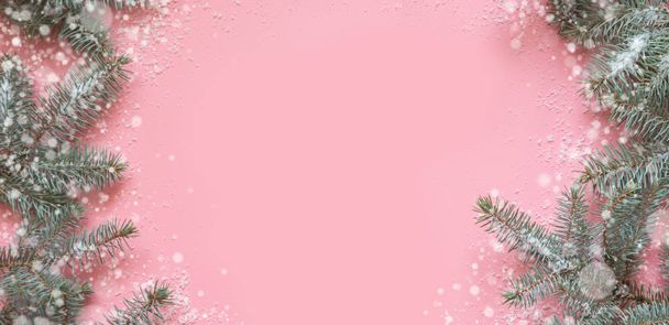 Christmas frame made of fir branches, festive white decor on pink table. Xmas background. Flat lay. Top view with copy space - Фото, зображення