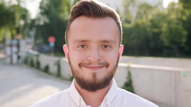 Jonge Man dragen een wit overhemd glimlachend in de stad - Video