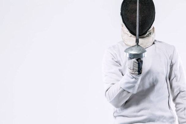 Fencer athlete wearing mask and white fencing costume and holding the sword, . Isolated on white background - Photo, Image