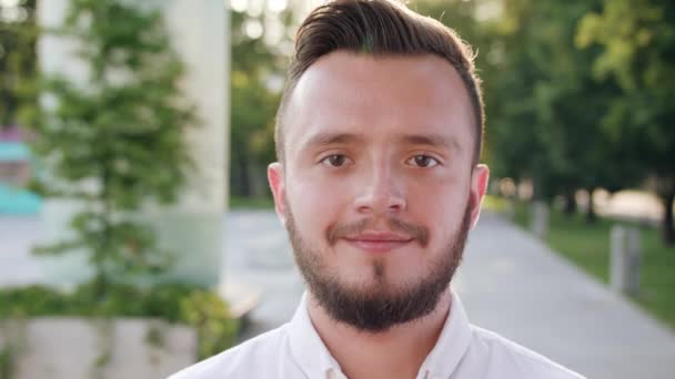 Νεαρός άνδρας, φορώντας ένα άσπρο πουκάμισο χαμογελώντας στην πόλη - Πλάνα, βίντεο