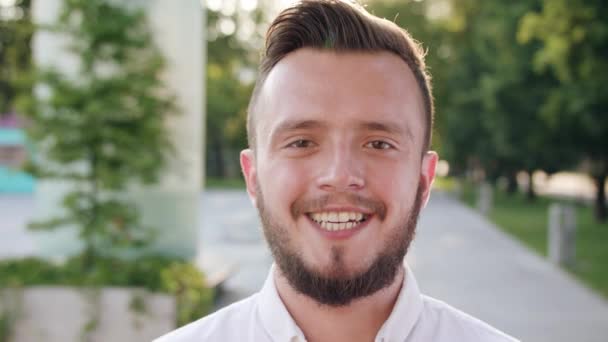 Giovane uomo che indossa una camicia bianca sorridente in città
 - Filmati, video