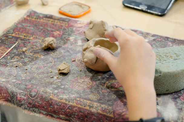 Дитина формує продукт з глини на уроці моделювання
. - Фото, зображення
