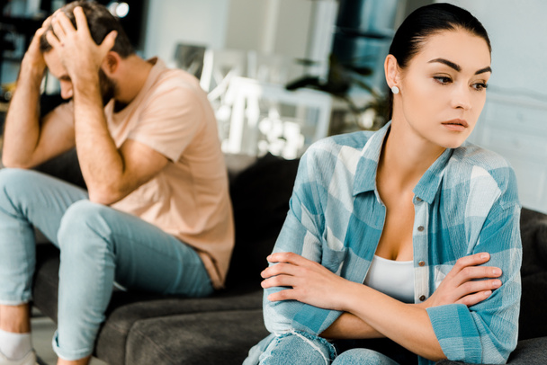 upset couple sitting on couch after arguing at home - Fotoğraf, Görsel