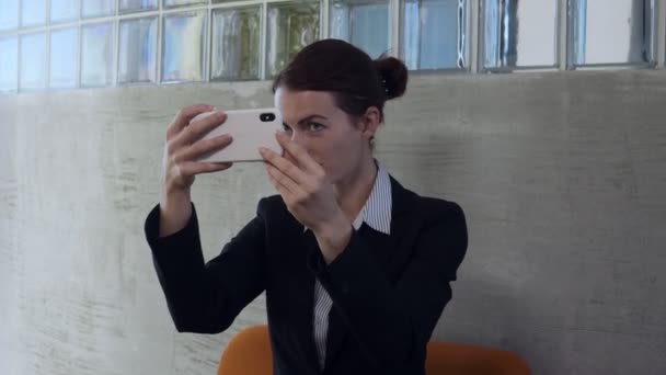 Business γυναίκα εξετάσουμε έξυπνο τηλέφωνο αντανάκλασης στο γυαλί και smarten. - Πλάνα, βίντεο