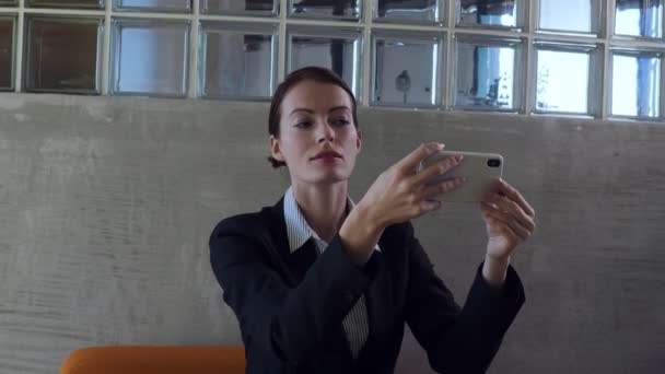 Mulher de negócios olhar para a reflexão de vidro do telefone inteligente e smarten up
. - Filmagem, Vídeo