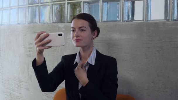 Mujer de negocios mirar en el reflejo de vidrio del teléfono inteligente y smarten, utilizando el dispositivo móvil como espejo
. - Metraje, vídeo