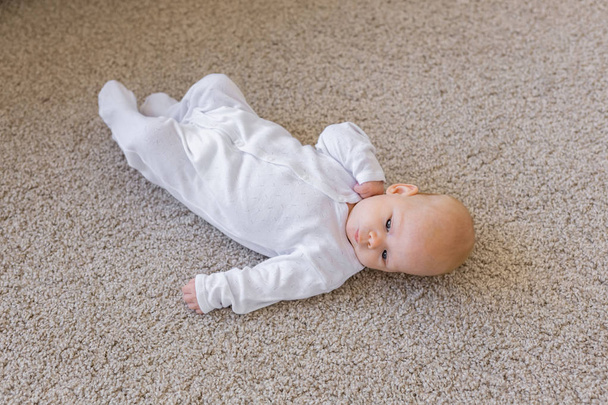 Οικογένεια, το μωρό και το βρέφος έννοια - εσωτερικη πορτρέτο μικρού παιδιού στο πάτωμα - Φωτογραφία, εικόνα