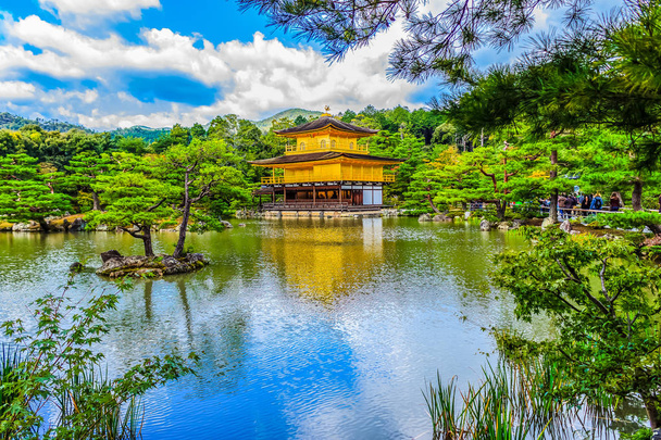 Όμορφη αρχιτεκτονική στο Kinkaku-ji (ναός του χρυσού περιπτέρου), επίσημα ονομάζεται Rokuon-ji (ελάφια Κήπος ναός), ένα ναό Ζεν βουδιστής στο Κιότο, Ιαπωνία. Kinkakuji Ναό κάτω από τον γαλάζιο ουρανό θολό ημέρα - Φωτογραφία, εικόνα