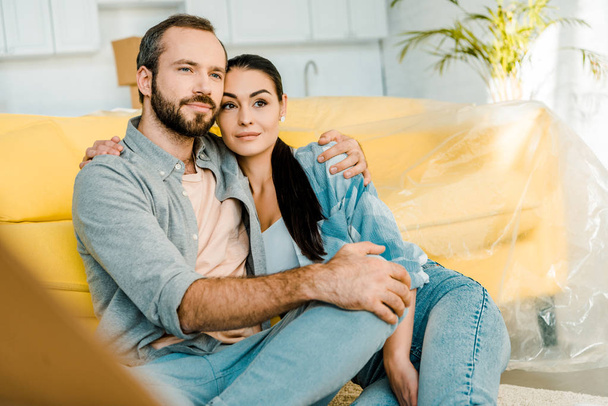 husband and wife sitting on couch after packing for new house, moving concept - Photo, Image