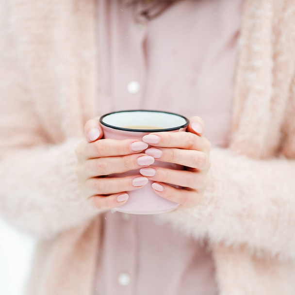 Beautiful female hands holding big pink cup of coffee - 写真・画像