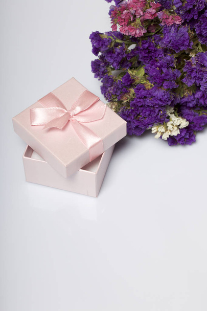 Wrapping presents. Gift boxes. Next is a bouquet of autumn dried flowers. On a white background. - Foto, Bild