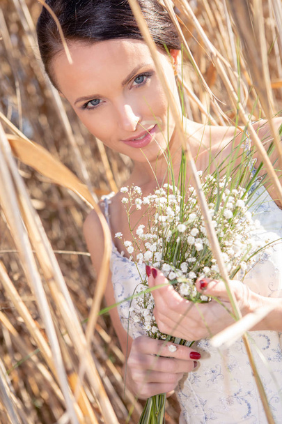 outdoor portrait of a bride with bridal bouquet in a wedding dress - Фото, изображение