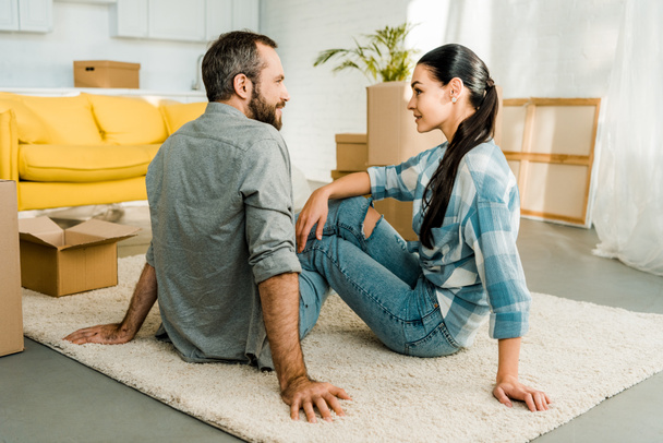 husband and wife sitting on floor while packing for new house, moving concept - Valokuva, kuva