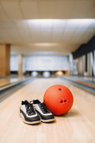 Bowling ball and house shoes on lane in club, pins on background, nobody. Bowl game concept, tenpin - Photo, Image