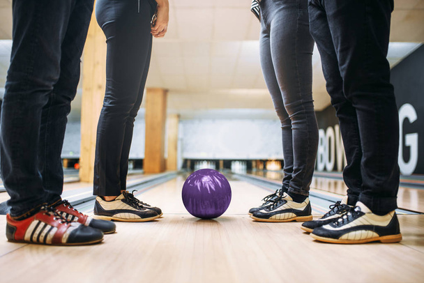 Bowling alley team, feet of the players in house shoes and ball on lane. Friends playing the game in club, active leisure - Photo, Image