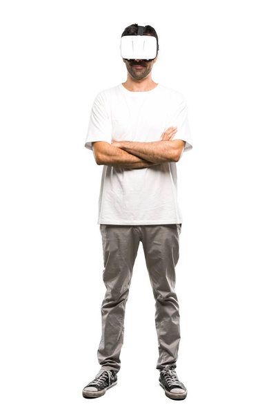 Una toma completa de un hombre usando gafas VR con los brazos cruzados sobre un fondo blanco aislado
 - Foto, imagen