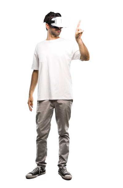 Una toma completa de un hombre usando gafas VR tocando una pantalla transparente sobre un fondo blanco aislado
 - Foto, imagen
