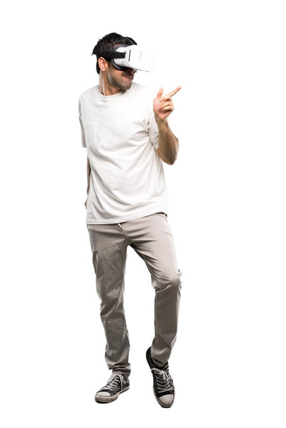 A full-length shot of a Man using VR glasses enjoy dancing on isolated white background - Photo, image