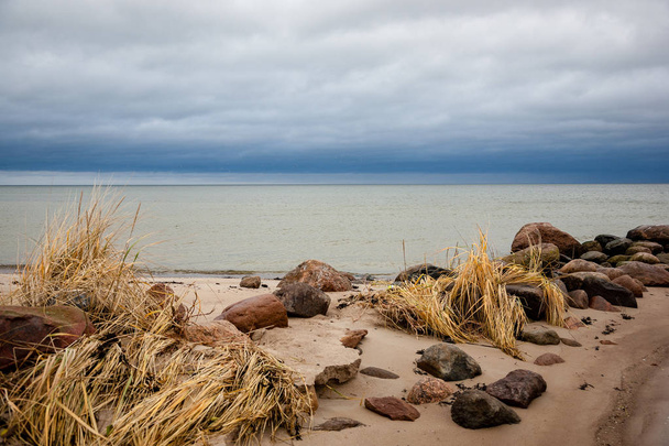 costa rochosa na Letónia com água corrente no mar e grandes rochas no final do Outono
 - Foto, Imagem