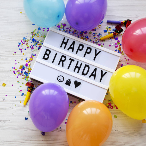 Lightbox with text 'Happy Birthday', decoration party on white wooden background, top view. Flat lay, overhead, from above. Closeup. - Photo, Image