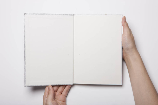La mujer tiene un libro vacío que se distribuye en la mesa blanca - Foto, Imagen