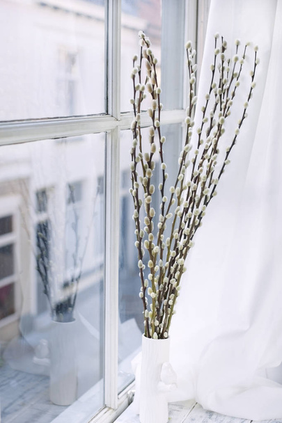 A bouquet of willow branches on the window in the house. Spring flowers. Home coziness and comfort. Free space for text. - Foto, imagen