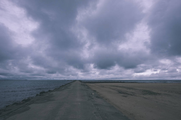 грязный пляж у моря с грозовыми облаками выше в спокойный вечер - винтажный старый фильм взгляд
 - Фото, изображение