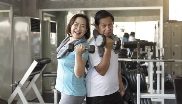 Asiatico anziano uomo e donna esercizio sollevamento manubri in palestra. anziani stile di vita sano. - Foto, immagini