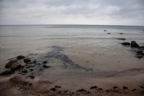 skaliste wybrzeże na Łotwie z przepływu wody w morzu i duże skały, późną jesienią - Zdjęcie, obraz