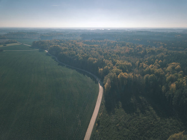 drone image. aerial view of rural area with fields and forests in cloudy autumn day with yellow colored fall trees - vintage old film look - Fotoğraf, Görsel