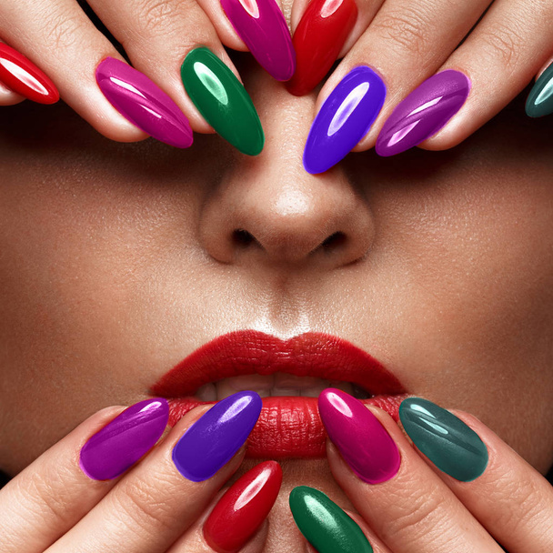 Beautiful girl with a classic make-up and multi-colored nails. Manicure design. Beauty face. - Foto, imagen