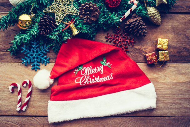 Vánoční ozdoby a klobouk "Merry christmas" pozdravy na dřevo pozadí. - Fotografie, Obrázek