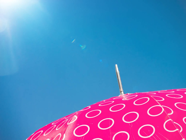 Růžový deštník modrá obloha pozadí a kopírovat prostor - Fotografie, Obrázek