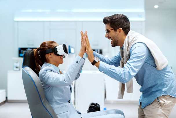 Feliz pareja multicultural probando la tecnología de realidad virtual. Tech tienda interior
. - Foto, Imagen