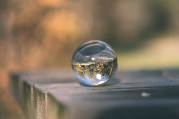 lensball in autumn reflecting nature around it - vintage old film look - Фото, изображение