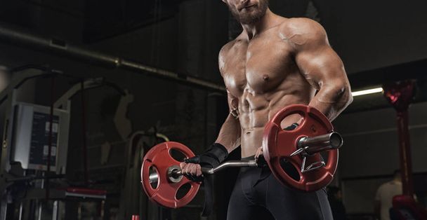 Muscular athletic bodybuilder fitness model posing after exercises in gym - Fotografie, Obrázek