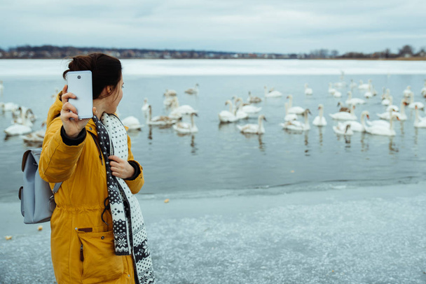 nő feed fagyasztott téli tó hattyúk - Fotó, kép