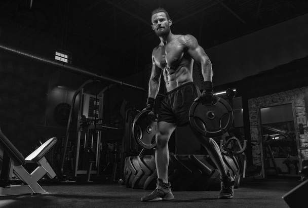 Muscular athletic bodybuilder fitness model posing after exercises in gym - Foto, Imagem