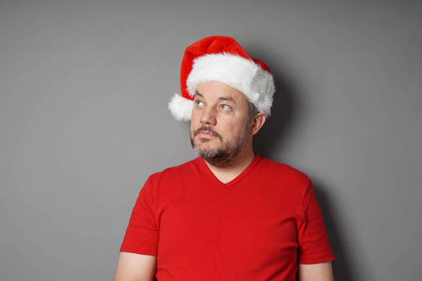homem usando chapéu de Papai Noel olhando para cima para copiar espaço
 - Foto, Imagem