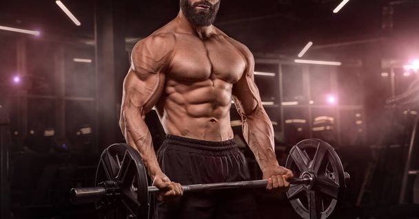 handsome man with big muscles trains in the gym, exercises - Фото, зображення