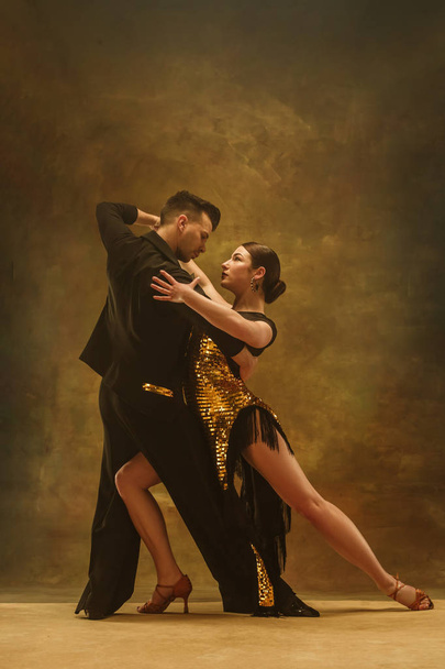 Dance ballroom couple in gold dress dancing on studio background. - Photo, Image