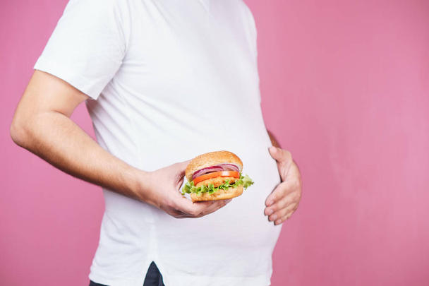 fast food, unhealthy eating. fat man with burger. - Foto, Bild